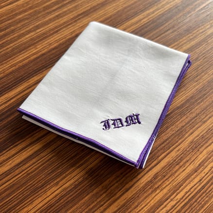 white handkerchief with purple hem and monogram